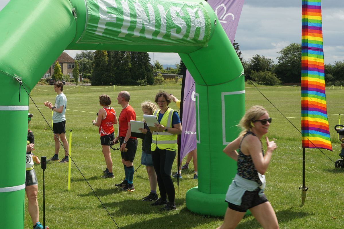 A runner finishing as marshals and spectators clap