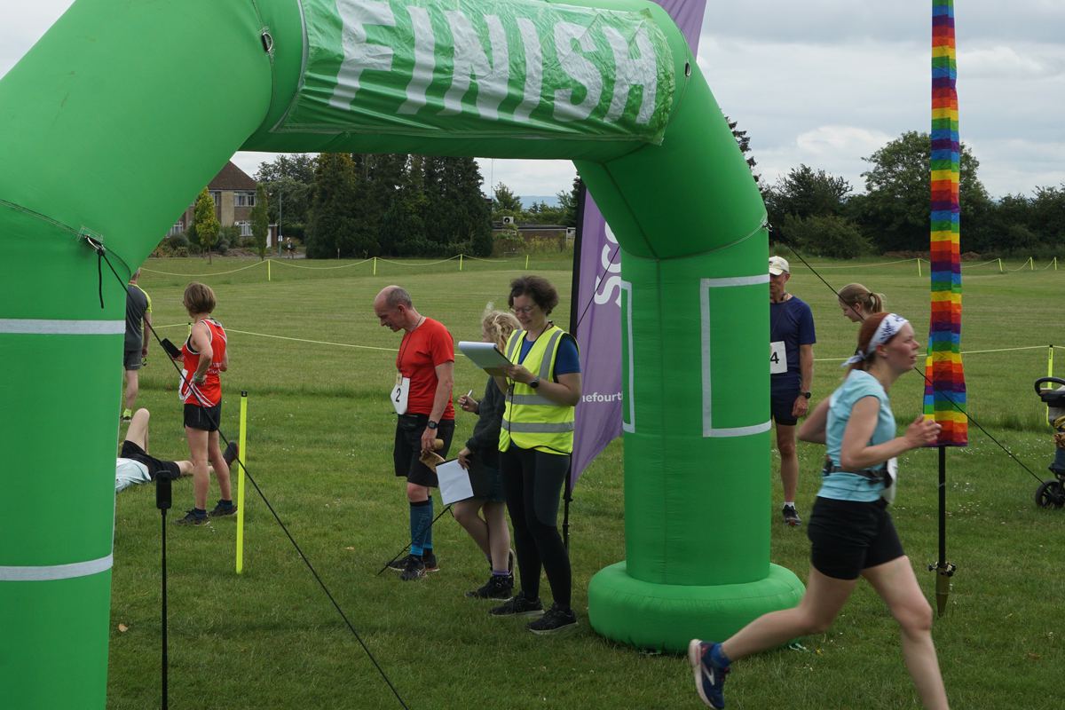 A runner sprinting for the line past a crowd of finishers